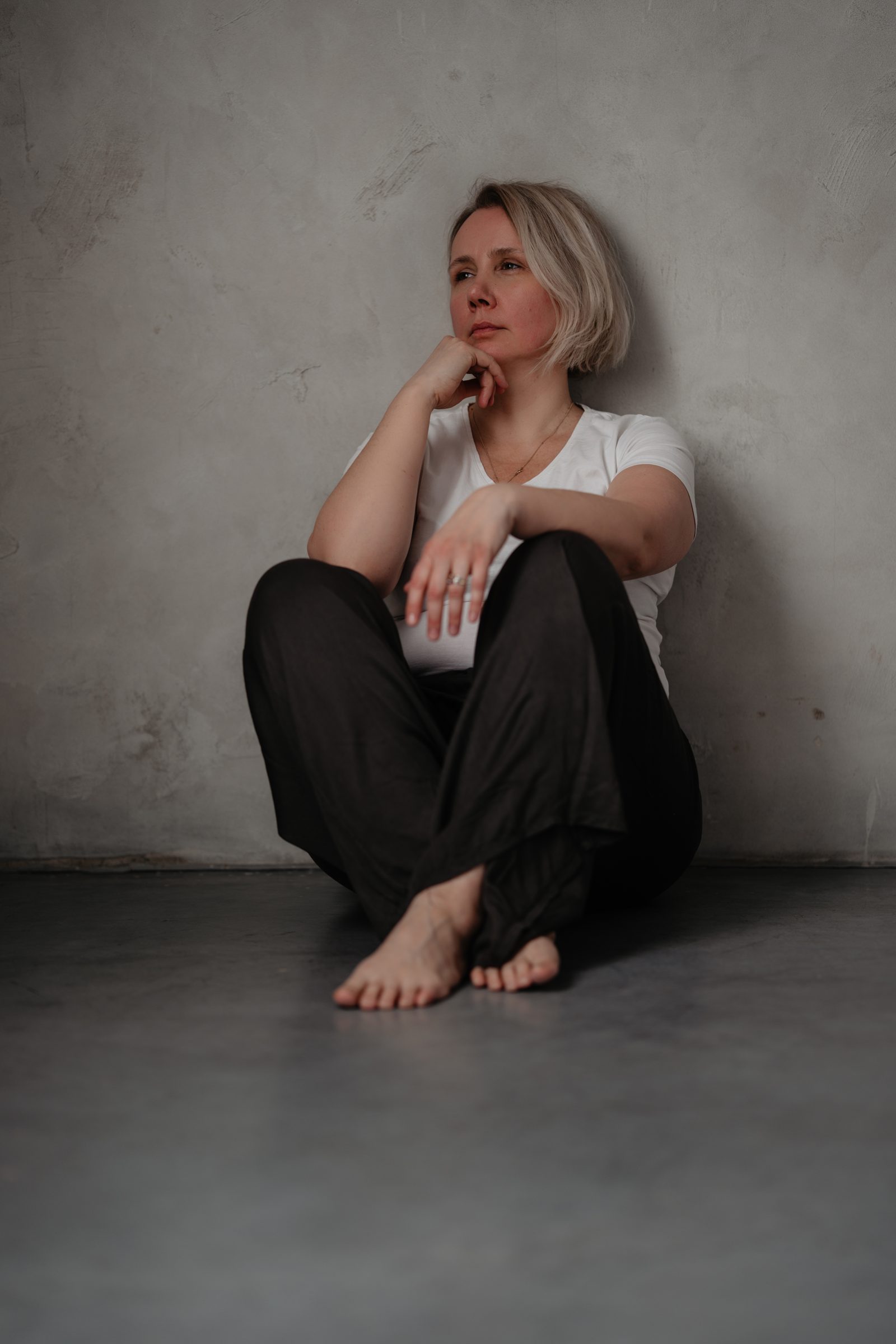 Magdalena Zarzecka siedząca przy ścianie w jasnej sali